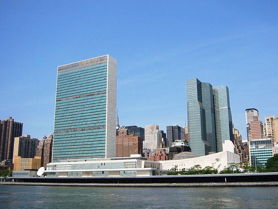 The headquarters of the UN in New York, a pair of glass-plate skyscrapers against the Manhattan skyline.