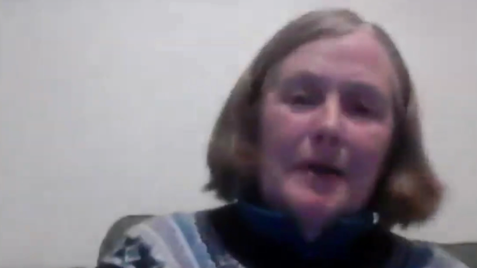 Helen McDade on laptop camera. She looks at the screen against a plain white background.